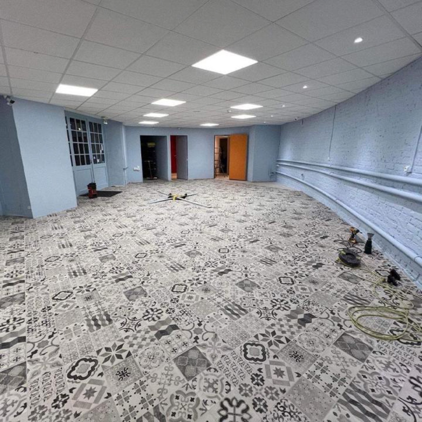 Grande salle rénovée : murs peints, carrelage à motifs