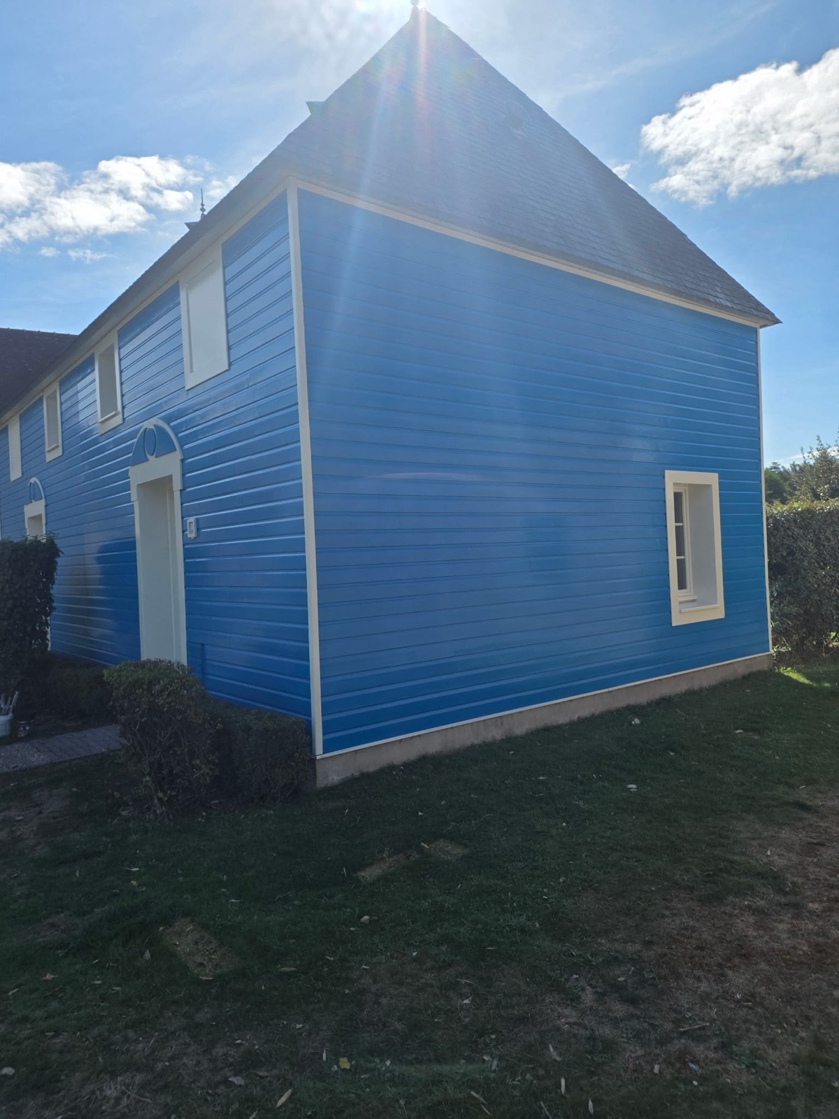 Villa repeinte en bleu, pignon en bardage